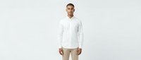 Young man with light skin tone wearing white long-sleeve button-up shirt and beige trousers, standing against neutral background. Suitable for business, casual fashion, lifestyle, and corporate marketing materials.