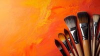 Professional art brushes arranged in fan shape against vibrant orange textured background with paint strokes, creating dramatic contrast for creative and artistic concepts.