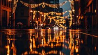 Festive street illuminated with golden Christmas lights reflecting on wet pavement creating magical holiday atmosphere in historic city center at night.