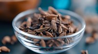 Dark chocolate shavings and curls in glass bowl on kitchen counter. Rich cocoa dessert ingredient for baking, cooking and confectionery preparation.