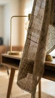Natural linen fabric draped over modern wooden furniture in warm sunlit interior creating cozy minimalist home decor atmosphere.