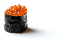 Fresh salmon roe gunkan sushi wrapped in crisp nori seaweed against white background, close-up view showing texture and shine of orange caviar.