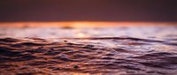 Ocean waves at sunset with warm golden light reflecting on water surface creating peaceful seascape atmosphere for relaxation and meditation backgrounds.