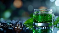 Luxurious green cosmetic gel in glass jar with water drops and fresh leaves on dark background with bokeh lights. Perfect for beauty product advertising.