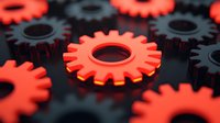 Red and black mechanical gears arranged in pattern showing industrial machinery parts, technology concept with selective focus on central cog wheel.