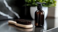 Amber glass pump bottle with wooden hair brush on modern bathroom counter. Natural organic skincare and haircare routine essentials for daily grooming.