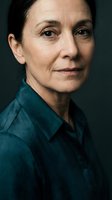 Professional mature woman in teal shirt portrait with natural lighting and confident expression for business and corporate communications.