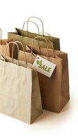 Eco-friendly kraft paper shopping bags with a sale tag on white background, promoting sustainable retail and green consumerism.