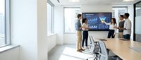 Business team analyzing financial data on large display screen in modern conference room with natural lighting and minimalist design for corporate presentations.