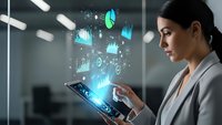 Professional businesswoman using digital tablet with holographic data visualization charts and graphs floating above screen in modern office environment.