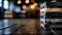 Weathered wooden pallets stacked on rustic floor with soft bokeh lights in background, creating moody industrial atmosphere with shallow depth of field.
