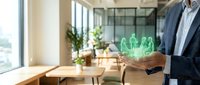 Professional businessman holding glowing green holographic family figures in modern office space representing insurance protection and financial planning.