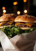 Fresh grilled beef patties with melted cheese on sesame buns, garnished with crisp lettuce, served in white paper wrapper against warm bokeh lights background.