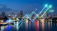 Financial growth chart with upward trending arrows overlaying blurred city skyline at night reflecting in water for business analytics presentations.