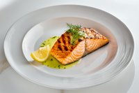 Ill garnish and lemon slice served on white plate with herb-infused olive oil sauce, restaurant quality presentation.