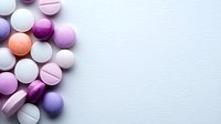 Colorful pharmaceutical pills and tablets in purple, pink, white and peach tones scattered on white background with copy space. Medical and healthcare concept.