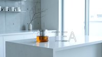 Glass teapot with brewed tea on a white marble kitchen island in a bright minimalist interior with large windows and shelf decor.