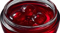 Red berry jam with whole berries in glass jar, homemade preserve spread for breakfast, organic fruit conserve, sweet dessert topping for bread and pastries.