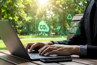 Businessman working on laptop with green environmental sustainability icons and CO2 reduction symbols for eco-friendly business solutions and climate action.