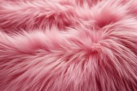 Soft pink fur texture with long fluffy fibers creating luxurious plush surface. Natural light highlights delicate strands and creates depth in furry material.