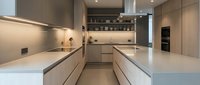 Modern minimalist kitchen interior with sleek cabinetry, white countertops, and integrated appliances in neutral tones for contemporary home design.