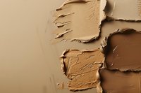 Smeared foundation makeup swatches showing different skin tone shades and textures on neutral background, closeup view of cosmetic product samples.
