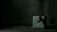 Elegant white gift box with burgundy ribbon bow positioned on weathered concrete floor against dark industrial wall, suitable for holiday marketing, luxury branding, and festive promotional campaigns.