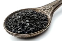 Black caviar on vintage silver spoon against white background, luxury gourmet food close-up macro photography showing texture and detail of sturgeon roe.