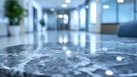 Modern office lobby with polished marble floor reflecting ceiling lights, empty hallway with potted plants and blue tinted contemporary interior design.