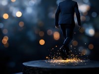 Businessman in dark suit leaping with magical golden light sparks effect against blurred bokeh background, creating dramatic silhouette and success concept.