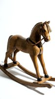 Vintage wooden rocking horse with real hair mane and braided leather bridle, isolated on white background for nursery and antique decor projects.
