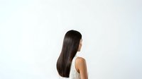 Young woman with long straight dark hair, East Asian ethnicity, wearing sleeveless top, shown in profile view against white background. Suitable for beauty, haircare, wellness and lifestyle design projects.
