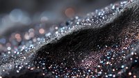 Macro view of sparkling glitter particles on dark surface with pink and blue reflections creating abstract bokeh effect. Perfect for luxury cosmetic backgrounds.