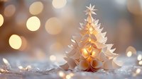 Paper craft Christmas tree with warm golden lights and bokeh background creates festive holiday atmosphere for seasonal decorations and greeting cards.