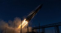 Powerful rocket launch with bright flames and smoke against dark night sky from industrial launch pad with metal support structures.