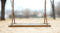 Empty wooden swing hanging from rusty chains in park on blurred autumn background, nostalgic childhood memories concept for social media and blogs.