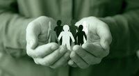 Protective hands holding paper cutout family figures representing care, security, insurance coverage, and social support services.