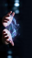 Hands of a young adult with light skin tone releasing glowing blue and purple energy waves against dark background, representing magic, power, technology, and innovation for digital design and creative projects.