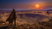 Lone traveler in hooded cloak stands on rocky cliff overlooking vast desert canyon at sunset with dramatic orange sky and distant mountains.