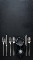 Elegant cutlery set with salt in small bowls arranged on dark slate background for culinary presentation and food styling projects.
