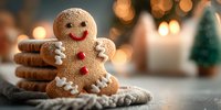 Gingerbread cookie man with white icing decoration and red buttons sits on burlap fabric with warm bokeh lights and Christmas tree in background for holiday baking.