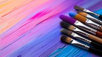 Paint brushes arranged diagonally against colorful pink, purple and blue artistic background with smooth gradient transitions and brush stroke textures. Suitable for creative design projects.