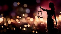Silhouette of Lady Justice holding scales against dramatic bokeh background with red and gold lights, symbolizing law, justice and legal system.