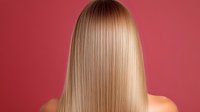 Straight blonde hair on pink background. Back view of smooth, glossy hair after keratin treatment or straightening procedure showing healthy shine and silky texture.