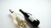 Two wine bottles with blank labels on white background, one white wine and one red wine bottle, mockup template for branding and label design projects.