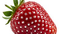 Fresh ripe strawberry with green leafy crown isolated on white background, ready for food and beverage design projects.