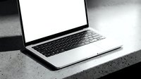 Modern laptop computer with blank white screen on concrete surface for business presentations and digital workspace mockups.