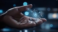Magical glowing particles floating above open palm in dark background with blue bokeh lights, representing dreams, innovation and spiritual energy.
