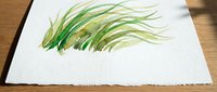 Watercolor grass blades painting on textured paper, organic botanical illustration with flowing green strokes for nature-inspired designs and decor.