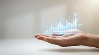 Business growth concept with holographic financial charts and graphs floating above open palm showing data analytics and market trends.
